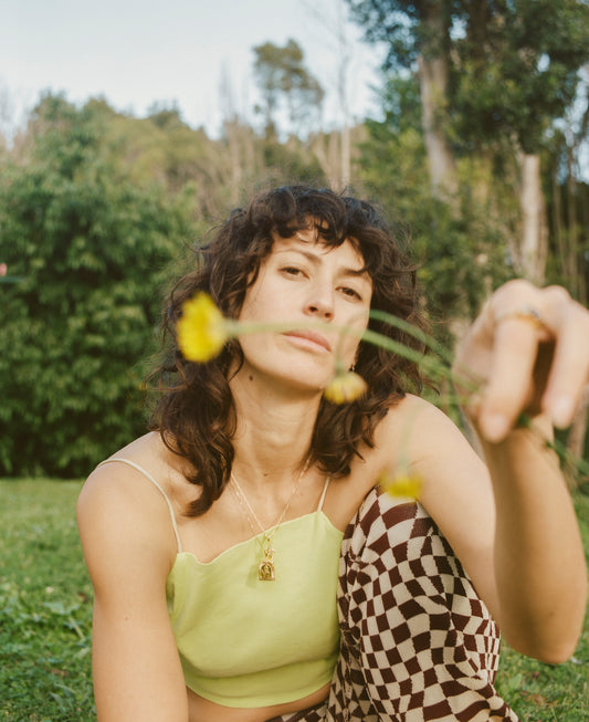 Gilli with dandelions, wearing Self Published Gold Vermeil jewellery from London UK