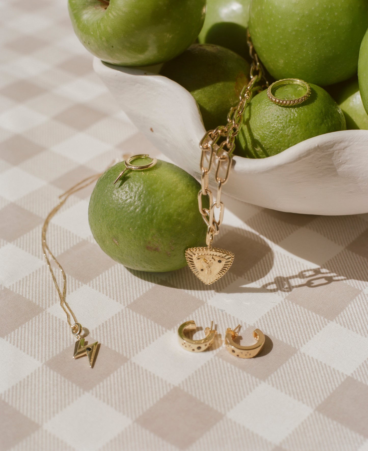 Gold jewellery and green apples